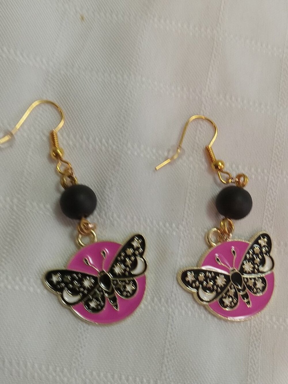 Handmade gold-colored earrings with multicolored enameled butterflies and beads